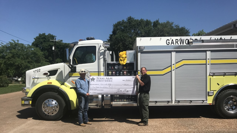 Garwood Fire Department members holding large check in front of Garwood Fire Truck