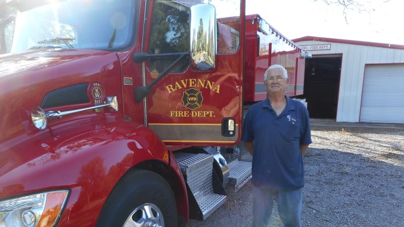 Ravenna VFD Chief stands next to new Ravenna Fire Truck Shown from front