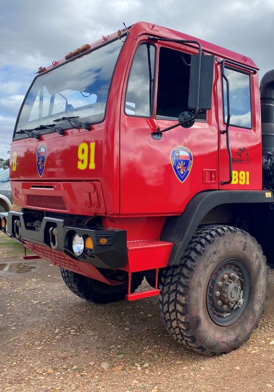 Military truck converted to red fire truck