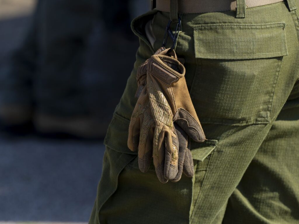 Work gloves hanging off of pants