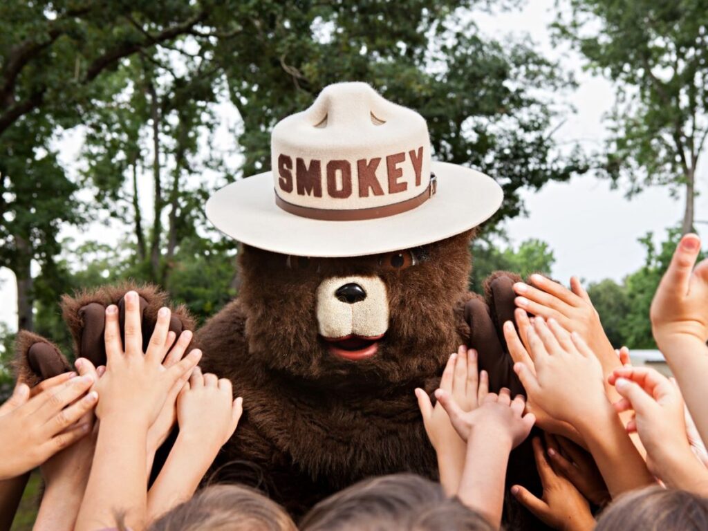 Smokey bear surrounded by kids