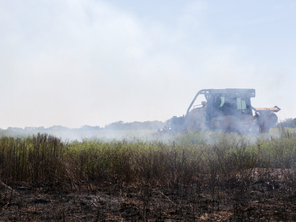 Un tractor CAT se encuentra en un campo lleno de humo
