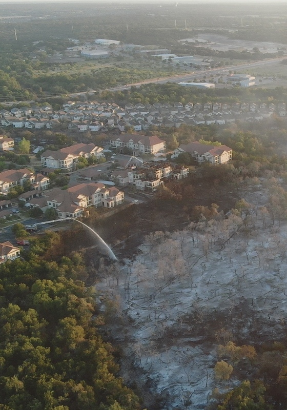 Vista aérea de un bosque quemado junto a una comunidad