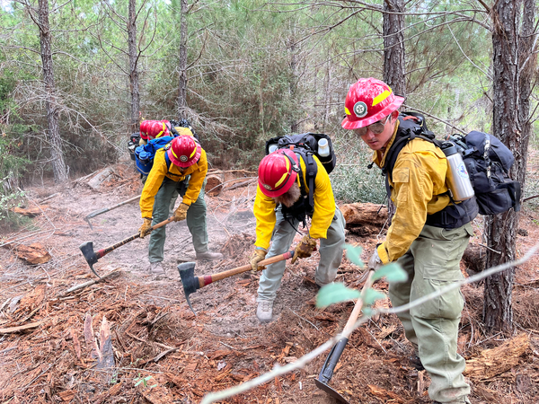 Students working together to control a fire during a training session