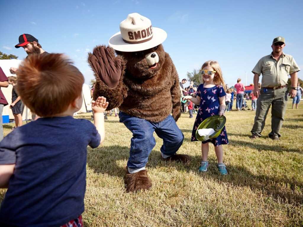 El oso ahumado choca los cinco con un niño