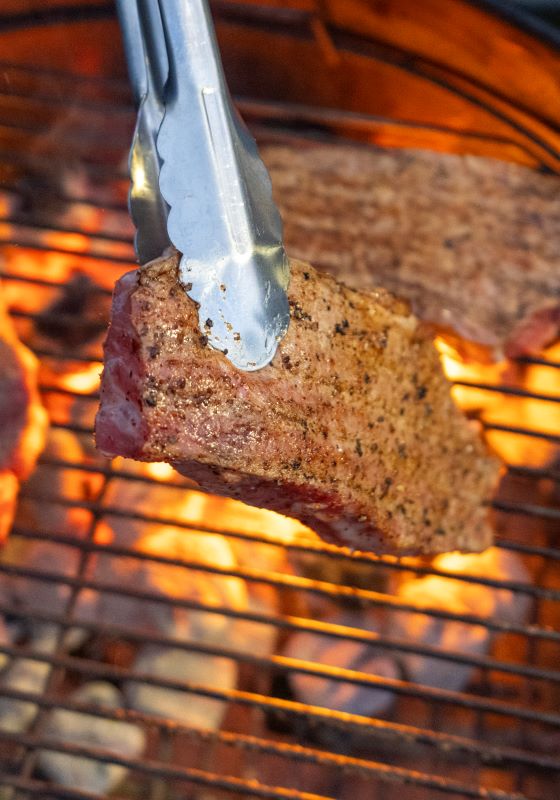 Meat on an grill with flames under grates
